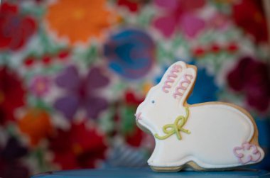 Çimlerin üzerinde iki Paskalya kurabiyesi ve beyaz çiçekler.