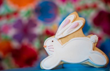 Çimlerin üzerinde iki Paskalya kurabiyesi ve beyaz çiçekler.