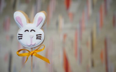 Çimlerin üzerinde iki Paskalya kurabiyesi ve beyaz çiçekler.