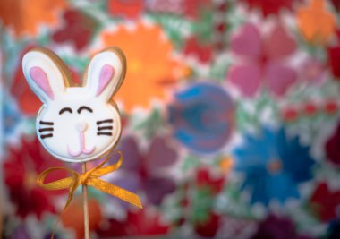 Çimlerin üzerinde iki Paskalya kurabiyesi ve beyaz çiçekler.