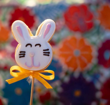 Çimlerin üzerinde iki Paskalya kurabiyesi ve beyaz çiçekler.