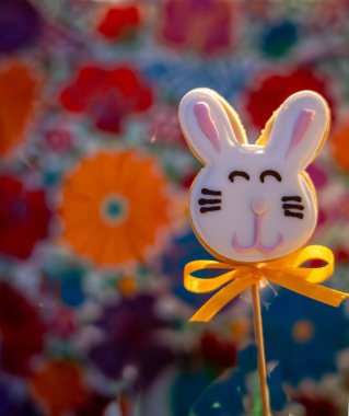 Çimlerin üzerinde iki Paskalya kurabiyesi ve beyaz çiçekler.