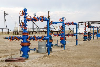 Group of wellheads and pipeline clipart