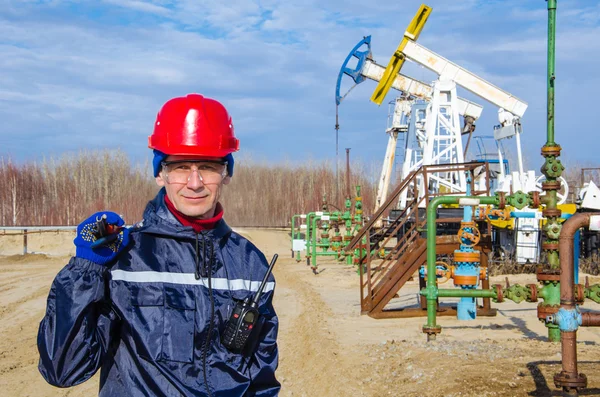 Oljefält Worker nära väl huvud och pump Jack — Stockfoto