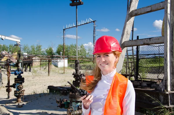 Femme sur le champ pétrolifère parlant à la radio — Photo