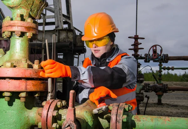 Woman engineer in the oil field repairing wellhead — Stock Photo, Image