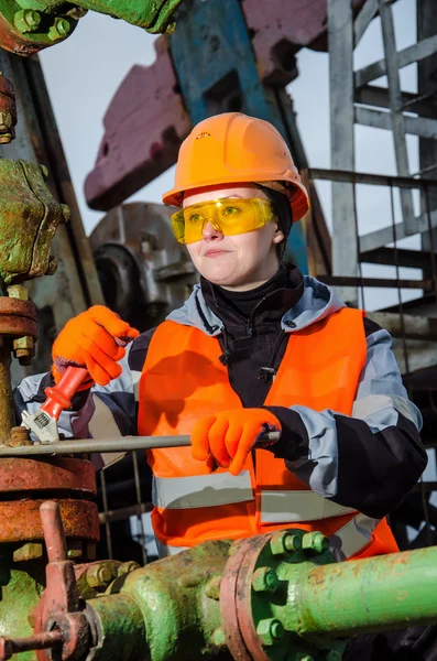 Woman engineer in the oil field repairing wellhead