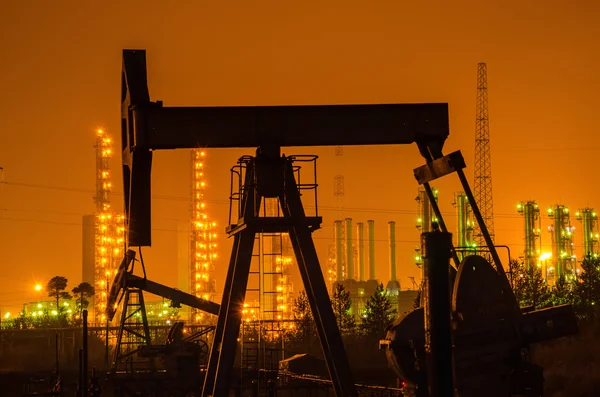 Silueta de plataforma de aceite en el fondo de la refinería por la noche . — Foto de Stock