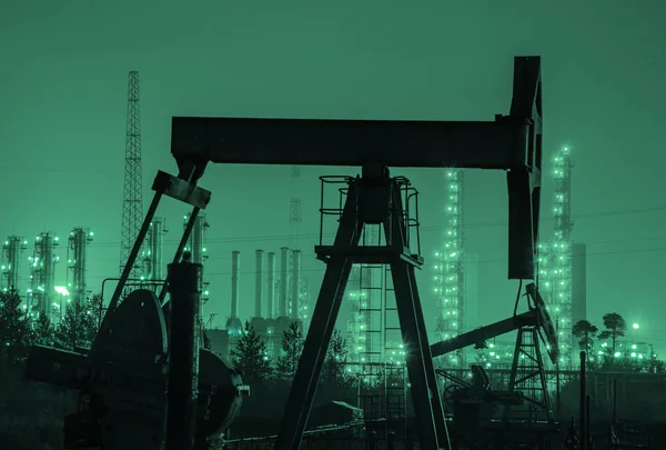 Silueta de plataforma de aceite en el fondo de la refinería por la noche . — Foto de Stock