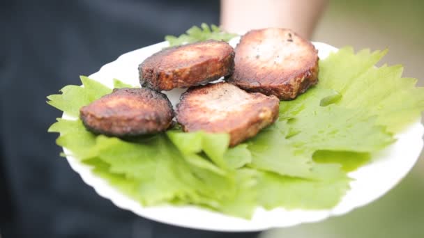 Мясо на тарелке с виноградными листьями — стоковое видео