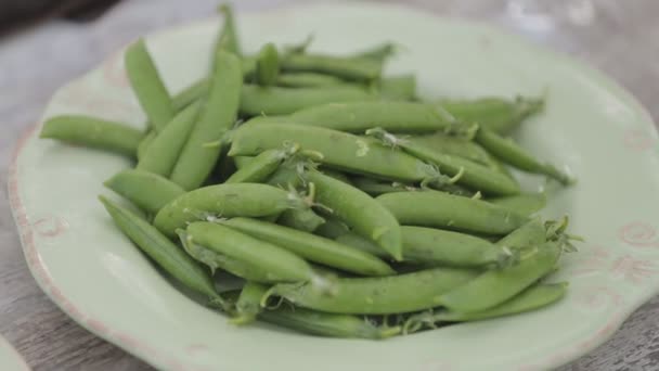 木製の背景に新鮮なエンドウ豆のプレート — ストック動画