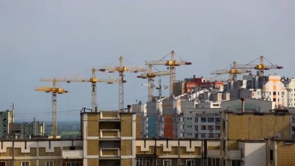 Stroyazihsya evleri en fazla. Birkaç Vinçler apartmanlar üst katlarına mavi gökyüzü, bulutlar bir arka plan üzerine inşa ediyoruz. Günbatımı — Stok video