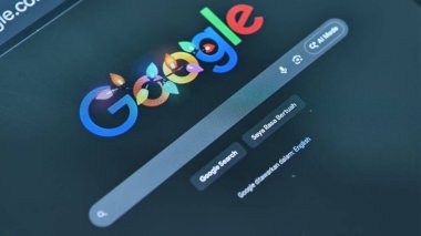 Google ana sayfasının renkli dizgi ışıkları, Malay 'da bir arama çubuğu ve dijital arama eğilimlerini vurgulayan bir 