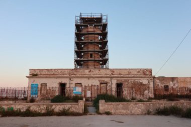 Syracuse, Sicilya, İtalya - 25 Ağustos 2020: Plemmirio yarımadasındaki Capo Murro di Porco deniz feneri gün batımında