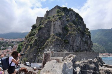 Scilla, Calabria, İtalya - 13 Haziran 2021: Liman uçurumunda eylem halindeki fotoğrafçı