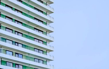 Daire balkonu, yeşil aksanlı ve çağdaş kaplamalı, sürdürülebilir yenilenebilir mod gösterim paneli, modüler camlı.