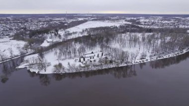 Orman kulübesi olan Hava Karlı Adası. Nehir Kıyısındaki Birch Ağaçları Arasında Küçük Ev, Kar