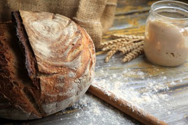 Köy ahşap arka planda mayalı ekmek ve başlangıç hamuru