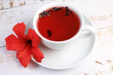 Tahta arka planda Hibiskus fincanı çayı ve amber yaprağı.