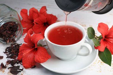 Tahta arka planda Hibiskus fincanı çayı ve amber yaprağı.