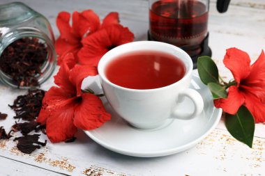 Tahta arka planda Hibiskus fincanı çayı ve amber yaprağı.