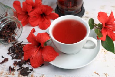 Tahta arka planda Hibiskus fincanı çayı ve amber yaprağı.