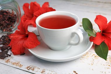 Tahta arka planda Hibiskus fincanı çayı ve amber yaprağı.