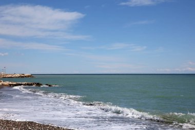 Deniz kıyısı ve bulutlu gökyüzü manzarası