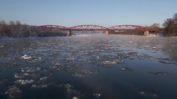 Drone Shot Muchy do przodu przez zamarzniętą rzekę do mostu Red Steel, widok z lotu ptaka wideo 4k — Wideo stockowe