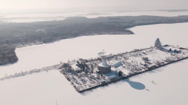 Вид з повітря на космічну станцію зв'язку у сніговому покритому полі на сонячний зимовий день, політ дрона над стратегічним об'єктом — стокове відео
