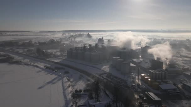 Vista aérea del dron de la fábrica de aceite de girasol con nubes de humo en invierno Temprano en la mañana — Vídeos de Stock