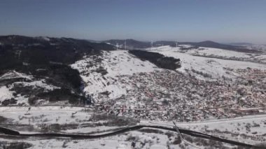 Sunny Winter Day 'de Kar Altında Rüzgar Türbininin Hava Görüntüsü ve Küçük Şehir, Yüksek Kaliteli 4k Video