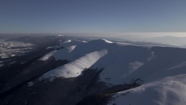 Vista aérea, vuelo de drones hacia adelante sobre las montañas Cárpatos en el soleado día de invierno, montaña de Gymba cubierta de nieve — Vídeo de stock