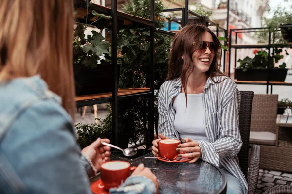 Two Young Women Drinking Coffee in a Cafe Outdoors, Lunch Time Concept, Brunette Girl in Focus — Stock Photo, Image