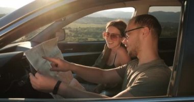 Bir arazi aracında otururken haritasını kullanan iki kişinin yan görünümü, yolculuk kavramı.