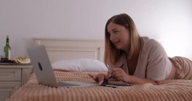 Genç Kadın Tasarımcı Otel Odasında Bir Yatakta Yatıyor ve Grafik Tableti ve Laptop, Serbest ve Uzaktan Çalışma Konsepti Üzerinde Çalışıyor