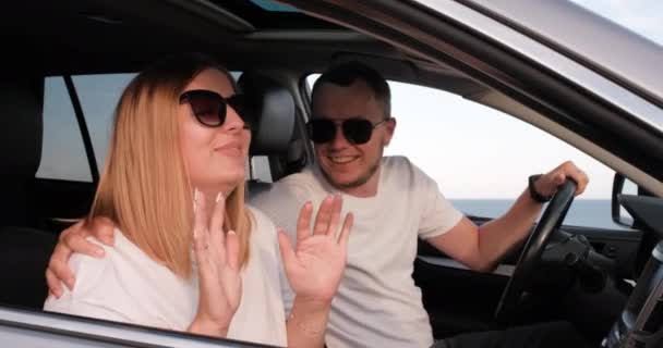 Ung man och kvinna som har roligt i bil med havsutsikt från fönstret, resor och Roadtrip i sommar — Stockvideo
