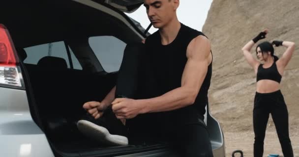 Dois atletas em Black Sportswear se preparando para treinar juntos ao ar livre perto do carro, estilo de vida saudável e conceito de treino ao ar livre — Vídeo de Stock