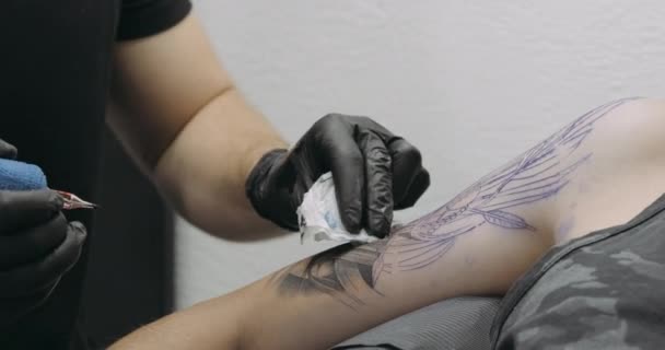 Close Up View of Tattooing Process, Nerozpoznatelný muž tetování umělec v černé gumové rukavice tvorby tetování na svého klienta — Stock video