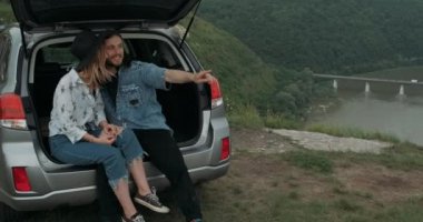 İki Genç Gezgin Araba Bagajında Oturuyor, Şık Erkek ve Kadın Giyinik Boho Style Keyifli Yolculuklar, Seyahat Konsepti