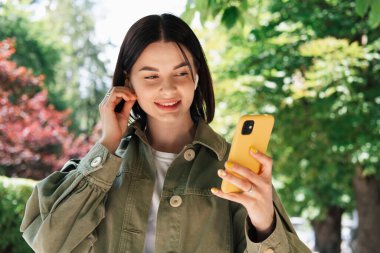 Şehirde Yürürken Akıllı Telefon Kullanan Genç Kadın, Açık Hava Cep Telefonu ve Kulaklık Kullanan Esmer Kız.