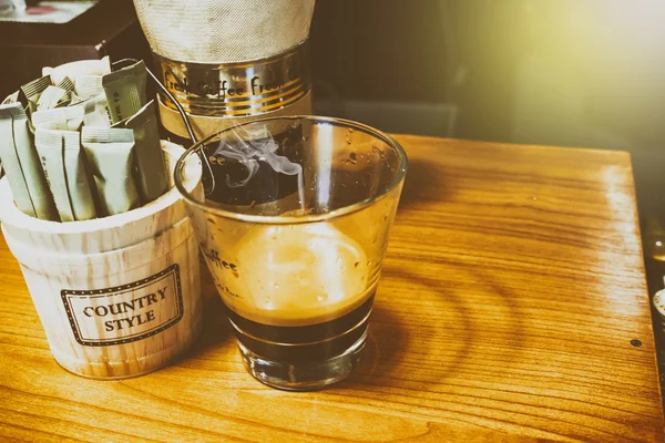 कॉफी की दुकान में लकड़ी की मेज पर ग्लास में काले कॉफी — स्टॉक फ़ोटो, इमेज