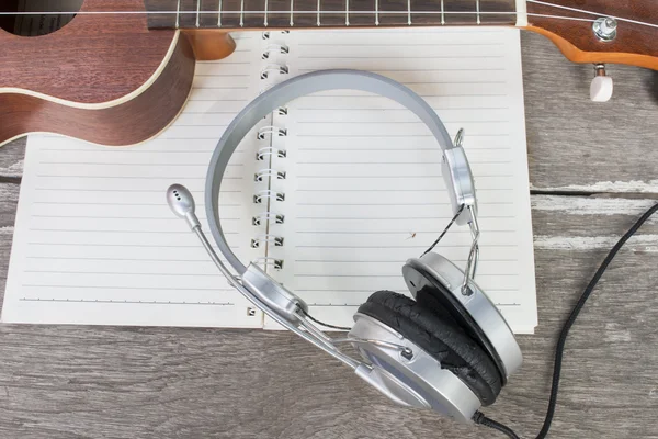 Headphone e ukulele no notebook — Fotografia de Stock