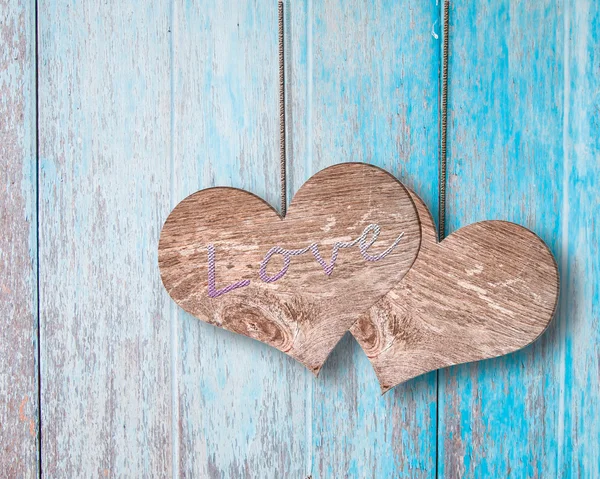 Couple heart hanging on blue wooden background — Stock Photo, Image