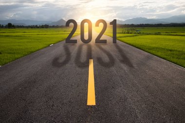 2021 'de otoyolda altın gün batımında, boş asfalt yolun ortasında yeni yıl kavramı.