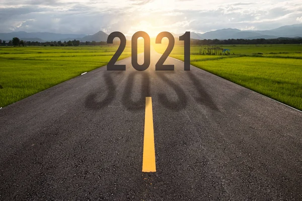 2021年という言葉は 黄金の日没で空のアスファルト道路の真ん中に高速道路の道路に書かれ 新年の概念 — ストック写真