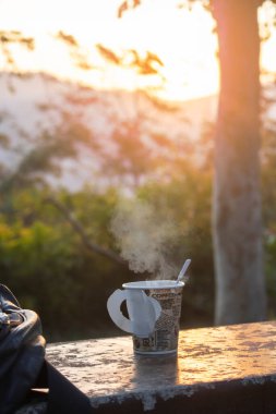 Parktaki masanın üzerinde bir fincan sıcak içecek kahvesi.