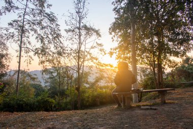 Genç adam güneşin doğuşuna bakıyor.