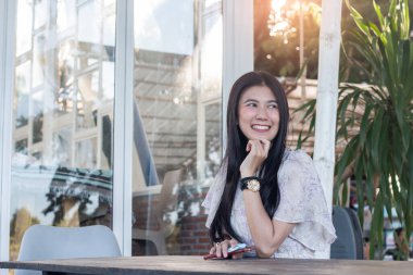 Kafede gülümseyen Asyalı kadın portresi.