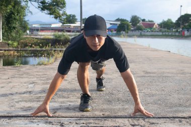 Formda ve kendine güvenen adam başlama pozisyonunda koşmaya hazır.